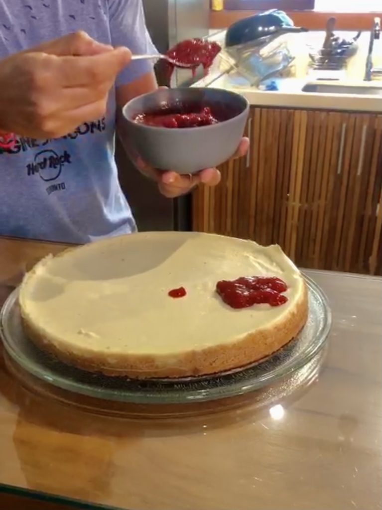 Cozinhar em casa cheescake com calda de morango 